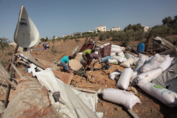 Palestinian men inspect a chicken farm damaged in an Israeli air strike in Bureij refugee camp in Gaza City, Gaza on June 29, 2014. Israeli warplanes launched a series of air strikes to the different part of the city early Sunday, after a rocket attack to a factory in southern Israel, causing damage but no injuries on Friday.  (Photo by Ashraf Amra/Anadolu Agency/Getty Images).