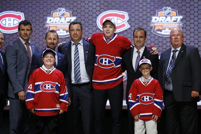 Nikita Scherbak stands with Montreal Canadiens officials after being chosen 26th overall during the first round of the NHL hockey draft, Friday, June 27, 2014, in Philadelphia. (AP Photo/Matt Slocum).