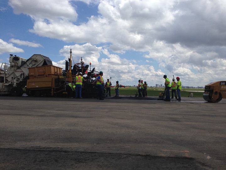 Roughly 100 people are working seven days a week to repave the airport's longer runway.