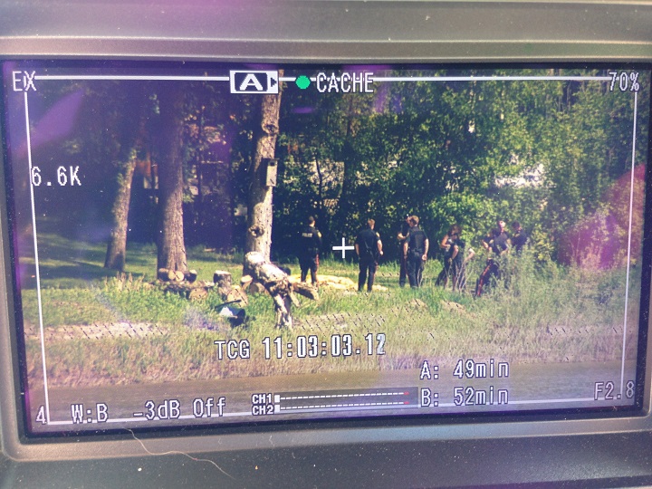 Winnipeg police officers on the banks of the Red River on South Drive, seen through a video camera viewfinder, on Wednesday June 4, 2014.