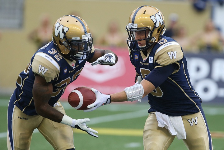 Winnipeg Blue Bombers QB Drew Willy hands off to RB Nic Grigsby during first-quarter CFL action against the Toronto Argonauts in Winnipeg on Thursday.