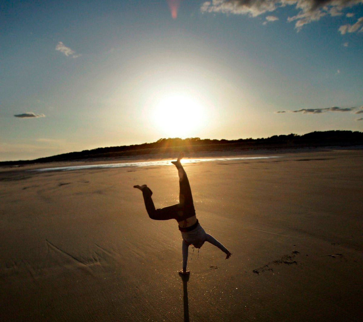 Flyn Costello celebrates the end of a fine day at Popham Beach by doing cartwheels at sunset, Monday, May 21, 2007, in Phippsburg, Maine.  (AP Photo/Robert F. Bukaty).