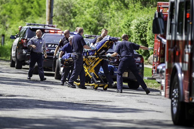 In this Saturday, May 31, 2014 photo, rescue workers take a stabbing victim to the ambulance in Waukesha, Wis. 