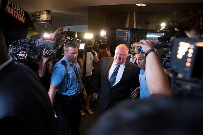 Toronto Mayor Rob Ford is greeted by a media throng as returns to his office at city hall in Toronto on Monday June 30, 2014,