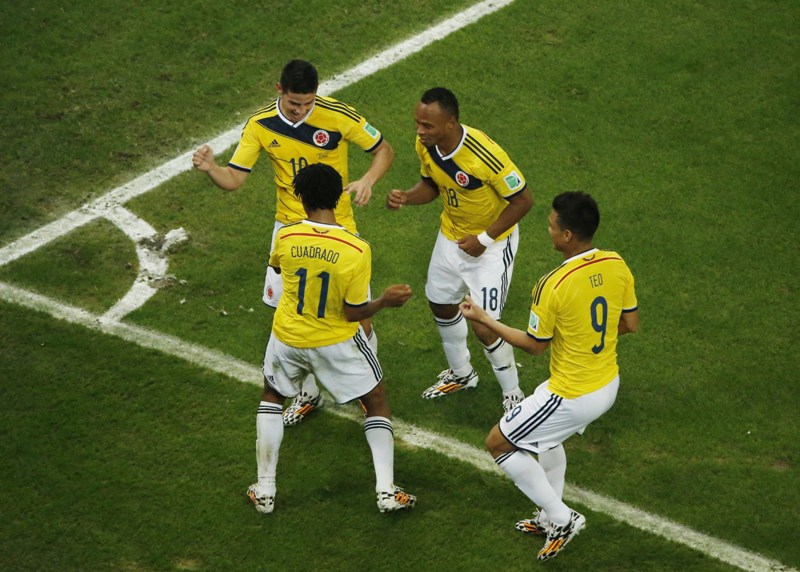 Colombia's midfielder James Rodriguez (L) dances with teammates Colombia's forward Teofilo Gutierrez (R), Colombia's midfielder Juan Guillermo Cuadrado (2L) and Colombia's defender Juan Camilo Zuniga (TOP) as he celebrates his second goal during the Round of 16 football match between Colombia and Uruguay at The Maracana Stadium in Rio de Janeiro on June 28, 2014,during the 2014 FIFA World Cup. AFP PHOTO / FABRIZIO BENSCH/POO.