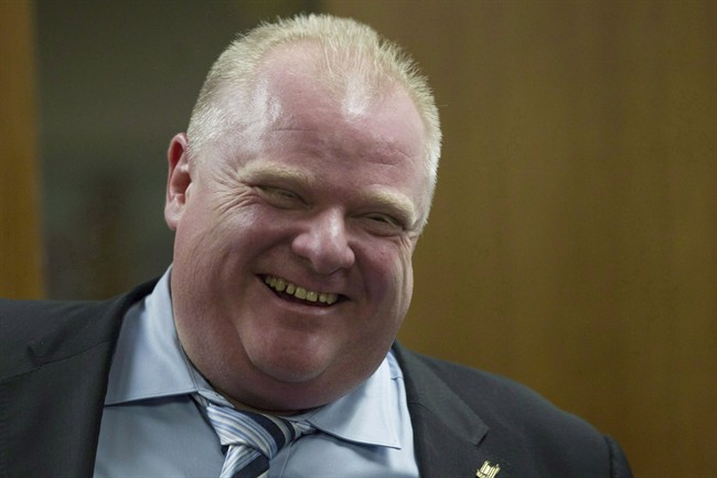 Toronto Mayor Rob Ford shares a laugh with one of his staff members outside his office at city hall in Toronto onWednesday, March 19, 2014. A stage musical is in the works about scandal-plagued Ford. THE CANADIAN PRESS/Chris Young.
