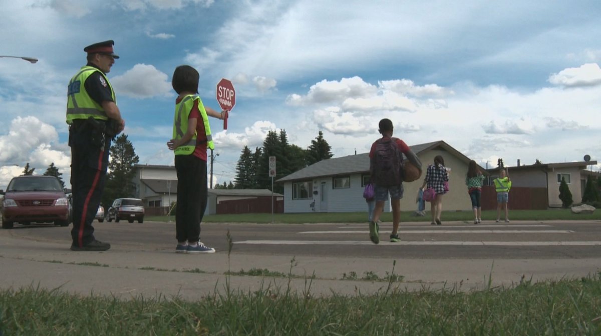 Edmonton Police Service traffic enforcement officer Cst. Tedd Benesch watches as students safely use a crosswalk on the last day of school. 
June 25, 2014.