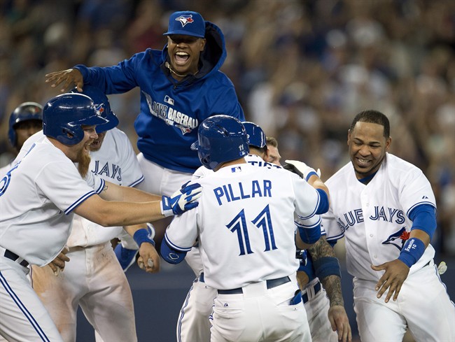 Toronto Blue Jays Jose Kevin Pillar is mobbed by teammates Adam Lind (left), Marcus Stroman (top) and Edwin Encarnacion (right) after hitting the game winning walk off single during 9th inning AL aciton against the Minnesota Twins in Toronto on Monday June 9, 2014. 