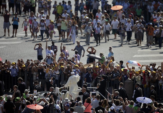Poeple gather to see Pope Francis drive by during his weekly general audience in St. Peter's Square at the Vatican, Wednesday, June 11, 2014.