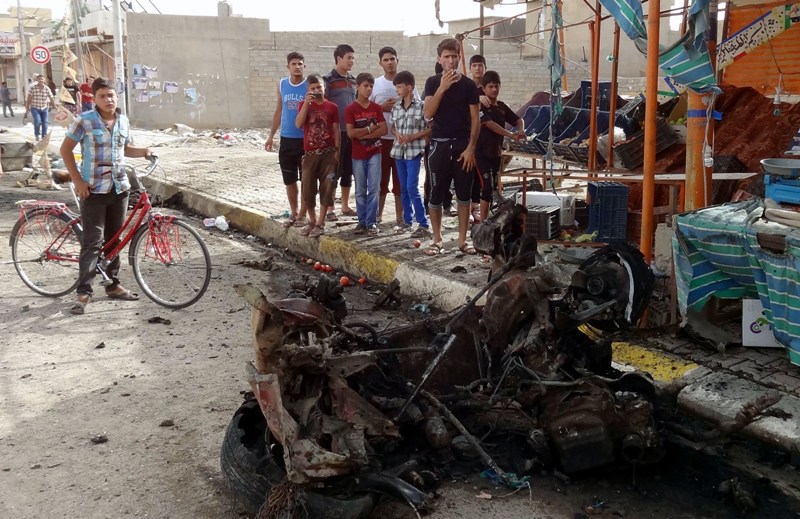 Iraqi youths inspect damages on the aftermath of a car bomb explosion in the northern city of Kirkuk, on June 6, 2014. Violence is running at its highest levels since 2006-2007, the height of the country's Sunni-Shiite sectarian conflict. More than 900 people were killed in Iraq last month, according to figures separately compiled by the United Nations and the government. AFP PHOTO / MARWAN IBRAHIM.