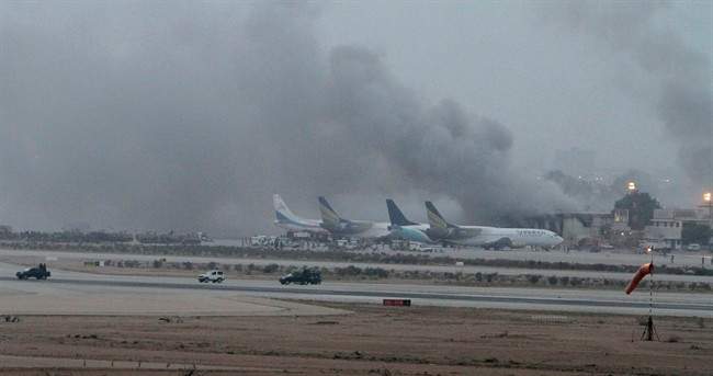 Smoke rises above the Jinnah International Airport where security forces continue to battle militants Monday, June 9, 2014, in Karachi, Pakistan. 