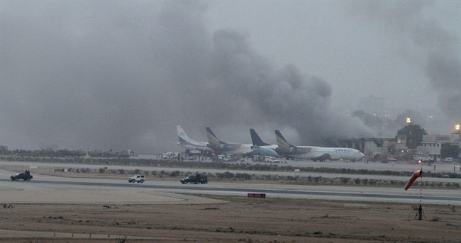 Smoke rises above the Jinnah International Airport where security forces continue to battle militants Monday, June 9, 2014, in Karachi, Pakistan. 