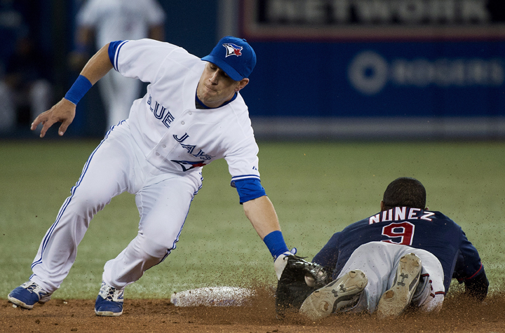 Toronto Blue Jays second baseman Steve Tolleson, left, tags out Minnesota Twins Eduardo Nunez, right, on the steal during eighth inning AL baseball action in Toronto on Tuesday, June 10, 2014.