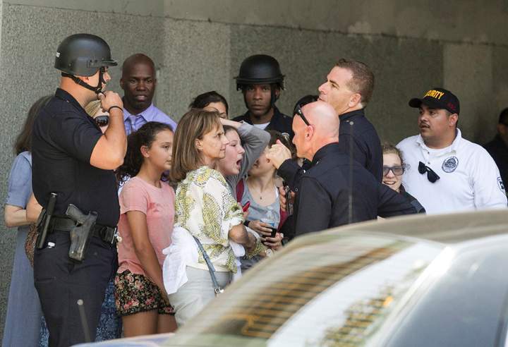Los Angeles Police officials escort Oakwood students and docents as they are evacuated after a motorist armed with an assault rifle led police on a high speed pursuit to the North Hollywood area of Los Angeles, Monday, June 9, 2014. 