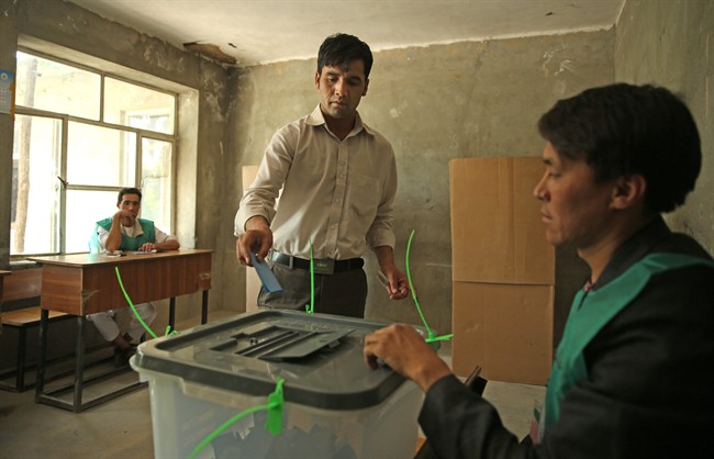 An Afghan man casts his vote at a polling station in Kabul, Afghanistan, Saturday, June 14, 2014. Despite a Taliban threat to stay away, Afghans lined up Saturday to vote in a presidential runoff between two candidates who both promise to improve ties with the West and combat corruption as they confront a powerful Taliban insurgency and preside over the withdrawal of most foreign troops by the end of the year. (AP Photo/Massoud Hossaini).