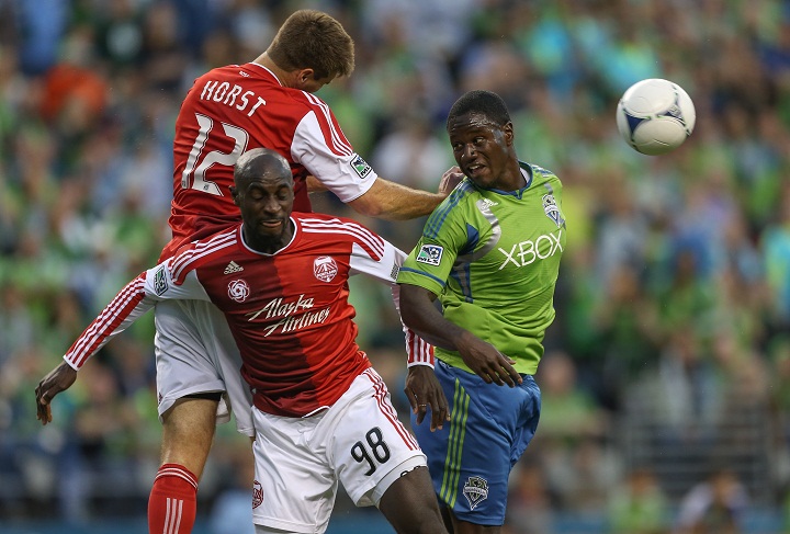 Eddie Johnson #7 of the Seattle Sounders FC battles David Horst #12, and Mamadou "Futty" Danso #98 of the Portland Timbers at CenturyLink Field on October 7, 2012 in Seattle, Washington.