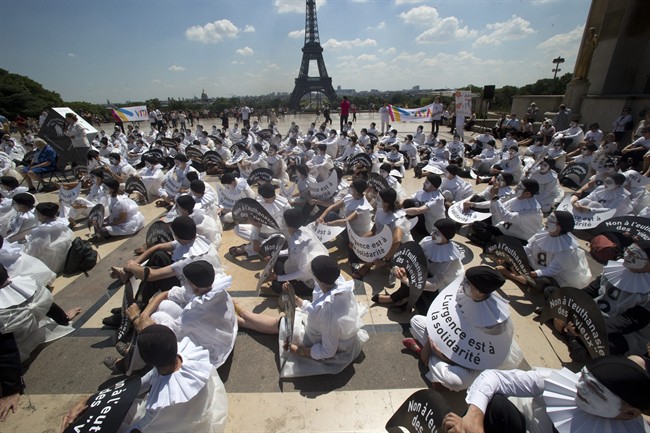 Demonstrators dressed as mime artists hold placards which read "no to the euthanasia of elderly people, solidarity is urgent", at Trocadero plaza in Paris, Tuesday June 24, 2014.