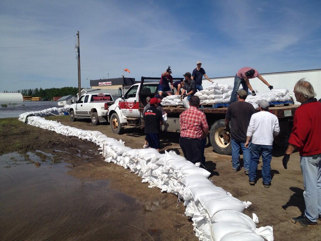 Volunteers work to stack sandbags in Melville, SK.