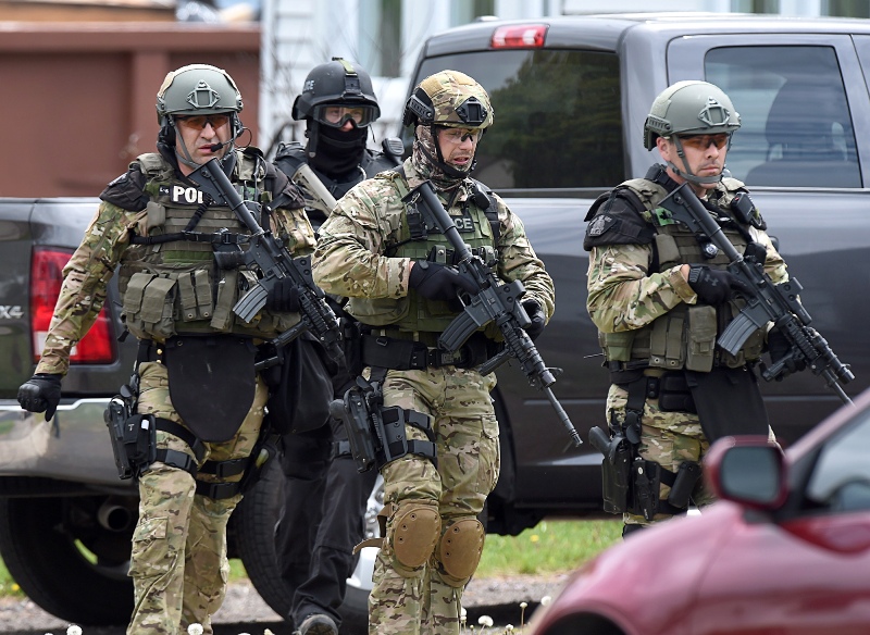 Emergency response officers check a residence in Moncton, New Brunswick, Thursday, June 5, 2014, searching for a suspect who shot and killed three Royal Canadian Mounted Police officers the day before. Wednesday. (AP Photo/The Canadian Press, Andrew Vaughan).