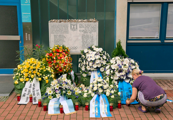 In this FILE photo, a woman lights candles in front of wreaths at a memorial at the former accommodation building of the Israeli Olympic team in Munich, southern Germany, Wednesday, Sept. 5, 2012, during a commemoration ceremony for the assassination victims of the Olympic games in Munich in 1972. 