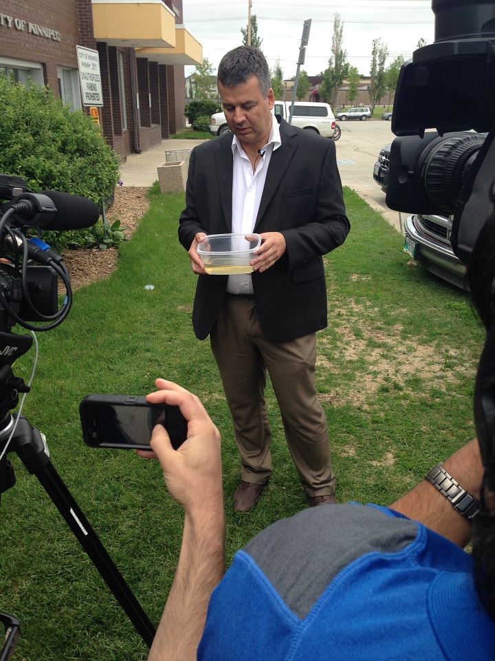 City Insect Control manager Ken Nawolsky shows a sample of water full of mosquito larvae.