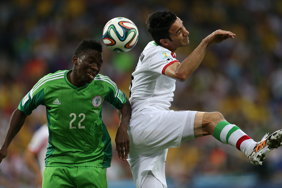 Nigeria's defender Kenneth Omeruo (L) fights for the ball with Iran's midfielder and captain Javad Nekounam during a Group F football match between Iran and Nigeria at the Baixada Arena in Curitiba at the 2014 FIFA World Cup on June 16, 2014. AFP PHOTO / BEHROUZ MEHRI (Photo credit should read BEHROUZ MEHRI/AFP/Getty Images)