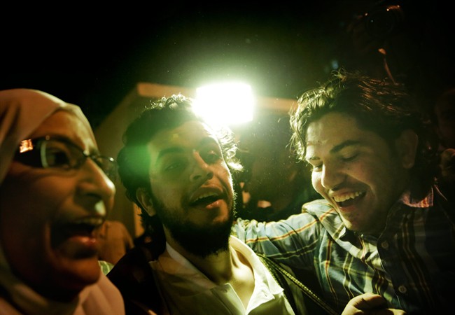 Al-Jazeera Arabic service journalist Abdullah Elshamy, center, who had been on hunger strike for more than four months to protest his prolonged detention without charges, speaks to the media as his brother Mos'aab Elshamy, right, greets him after his release from detention in Cairo, Egypt, Tuesday, June 17, 2014.