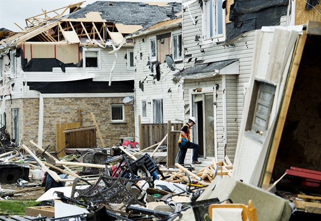 Investigators assess the damage to homes and property on Wednesday, June 18, 2014, a day after a tornado touched down in Angus, Ont . 