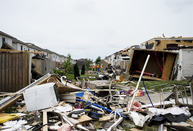Investigators assess the damage to homes and property in Angus, Ont. on Wednesday, June 18, 2014.