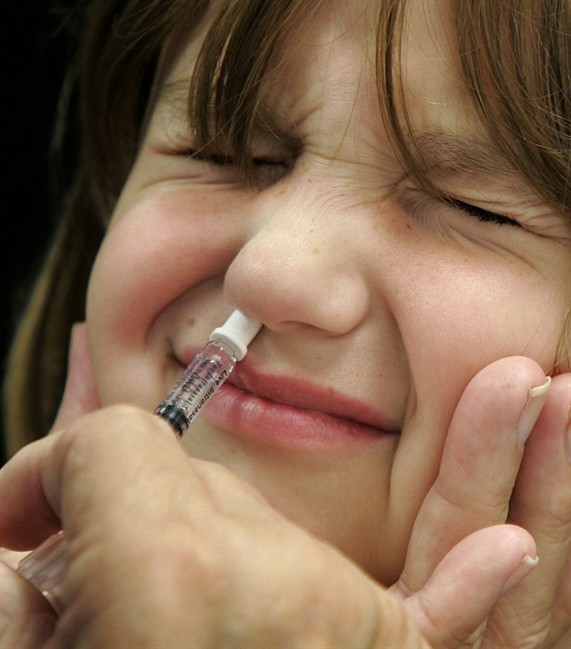 Amanda Klopfer reacts as she is given a FluMist influenza vaccination in St. Leonard, Md. A Federal advisory panel agreed on Wednesday, June 25, 2014, to tell doctors that FluMist nasal spray is a bit better at preventing flu in healthy young kids. 