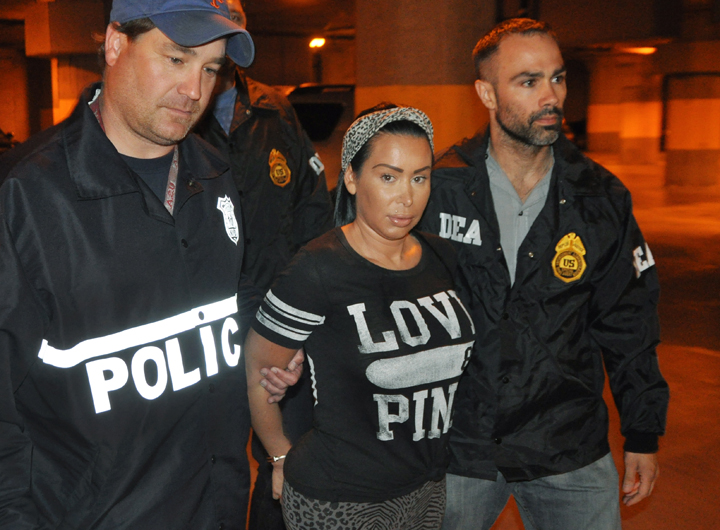 In this Monday, June 9, 2014 photo provided by the Drug Enforcement Administration, Samantha Barbash, center, is escorted by law enforcement officers following her arrest in New York. Barbash is allegedly part of a crew of New York City strippers who scammed wealthy men by drugging them and running up extravagant bills at topless clubs while they were in a daze, according to authorities.