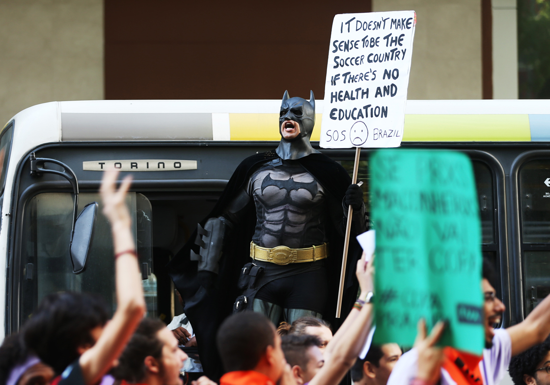 RIO DE JANEIRO, BRAZIL - JUNE 12: A person in a Batman costume holds a sign during an anti-World Cup demonstration on June 12, 2014 in Rio de Janeiro, Brazil. This is the first day of World Cup play. (Photo by Joe Raedle/Getty Images)
