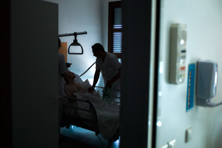 Nurses treat a patient at the palliative care unit of the Argenteuil hospital in the suburbs of Paris on July 22, 2013. 