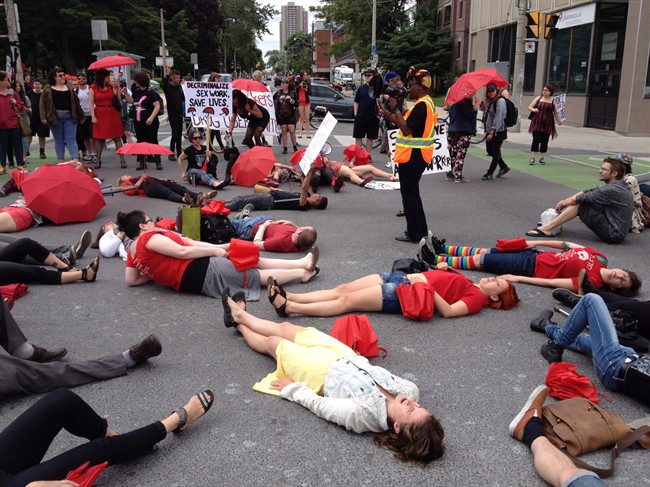 Demonstrators protest the Harper government's proposed prostitution legislation on a Toronto street Saturday, June 14, 2014.