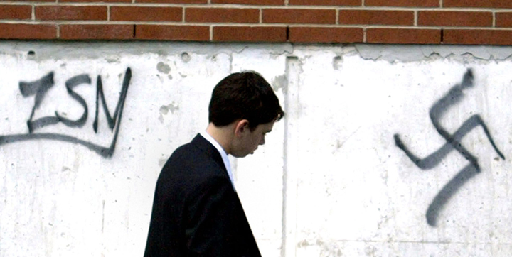 In this FILE photo, Joel Hameiri, 13, walks past graffiti on the Beth Shalom Synagogue after celebrating his Barmitzvah on Sunday June 20, 2004 in Ottawa. Police sent in their hate crimes unit to investigate. 