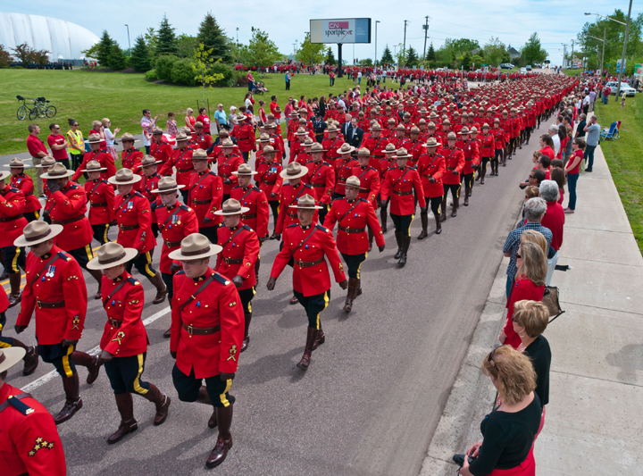 RCMP officers march in the funeral procession on their way to the regimental funeral for three slain RCMP officers in Moncton, N.B., Tuesday, June 10, 2014.