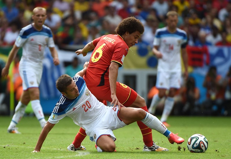 Russia's midfielder Viktor Fayzulin and Belgium's midfielder Axel Witsel (top) vie for the ball during a Group H football match between Belgium and Russia at the Maracana Stadium in Rio de Janeiro during the 2014 FIFA World Cup on June 22, 2014. AFP PHOTO / CHRISTOPHE SIMON .