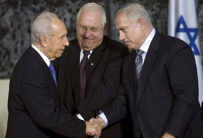 FILE - In this April 1, 2009, file photo, Israeli President Shimon Peres, left, greets Israeli Prime Minister Benjamin Netanyahu, right, as Knesset speaker Reuven Rivlin stands near during a handover ceremony at Peres' residence in Jerusalem.