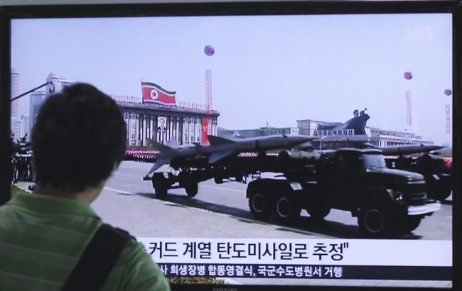 A man watches a TV news program showing file footage of a North Korean rocket carried during a military parade at Seoul Railway Station in Seoul, South Korea.