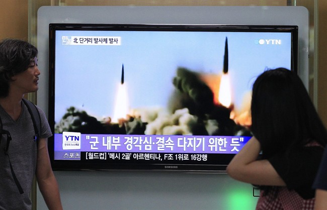 People watch a TV news program showing the missile launch conducted by North Korea, at Seoul Railway Station in Seoul, South Korea, Thursday, June 26, 2014. North Korea fired three short-range projectiles Thursday into the waters off its east coast, a South Korean defense official said. The move was most likely a routine test-firing, but the official said it could also be meant to stoke tensions with Seoul. The writing on the screen reads "The missiles were launched to alert and express its internal solidarity.".