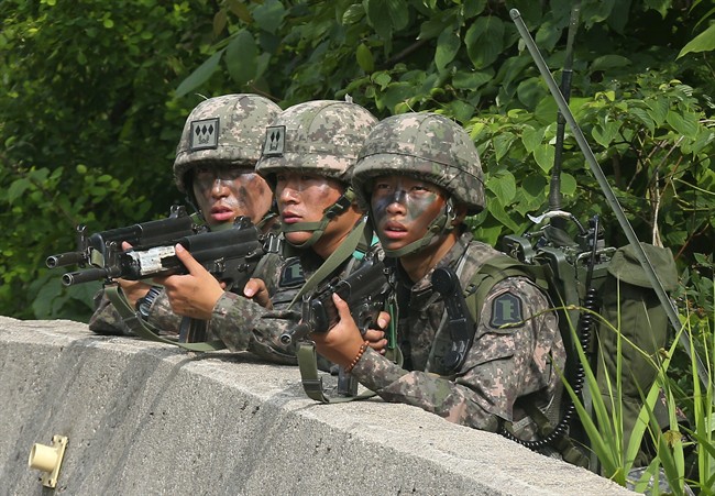 South Korean army soldiers aim their machine guns during an arrest operation in Goseong, South Korea, Monday, June 23, 2014. 