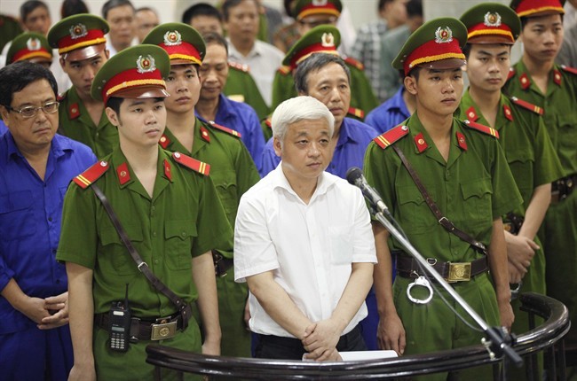 Nguyen Duc Kien, centre, former vice chairman of the founding council of the Asia Commercial Bank (ACB), appears at the Hanoi People's Court in Hanoi, Vietnam, Monday, June 9, 2014.