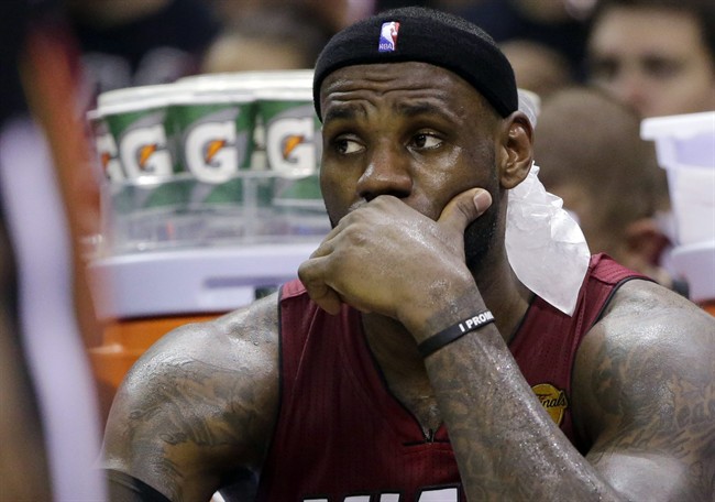 Miami Heat forward LeBron James watches action against the San Antonio Spurs during the second half in Game 1 of the NBA basketball finals on Thursday, June 5, 2014 in San Antonio. 