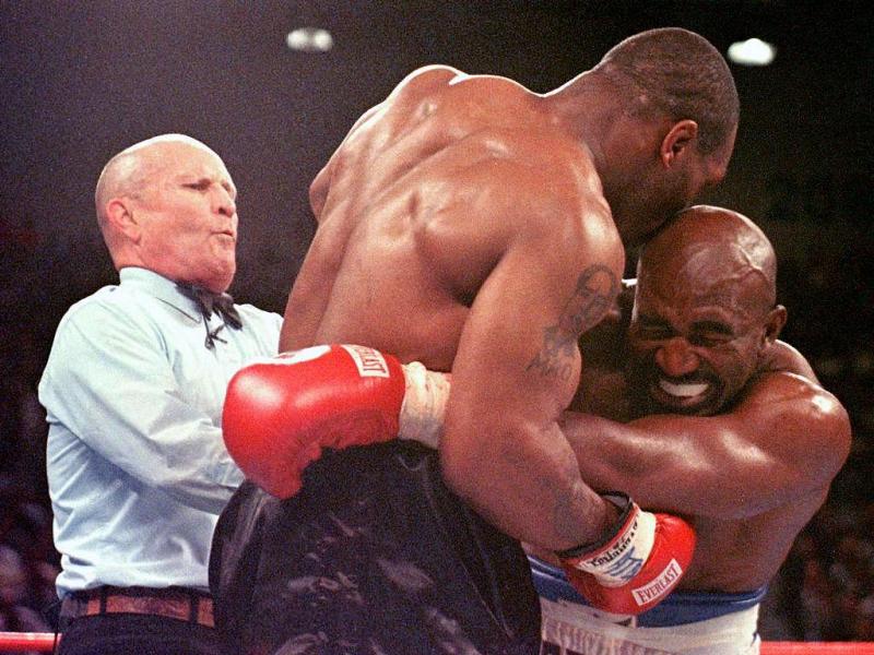 Referee Lane Mills (L) steps in as Evander Holyfield (R) reacts after Mike Tyson bit his ear in the third round of their WBA heavyweight championship fight at the MGM Grand Garden Arena in Las Vegas, NV 28 June. . AFP PHOTO/JEFF HAYNES