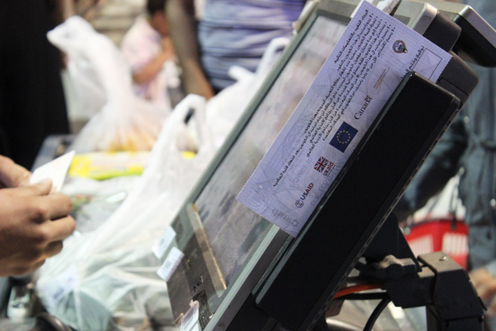 A customer pays for their groceries using a voucher