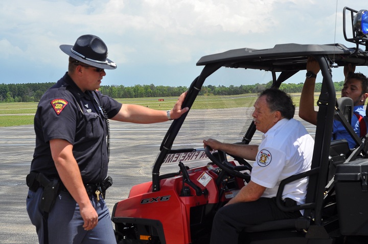 A Wisconsin State Patrol trooper, left, speaks with Stockton Fire Department crew members following a plane crash at the Stevens Point Air Show, Sunday, June 1, 2014, in Stevens Point, Wis. 