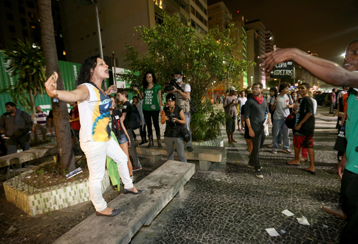 A soccer fan (L) and anti-World Cup protestors yell at each other at a restaurant that was showing the game on Copacabana beach on June 12, 2014 in Rio de Janeiro, Brazil.