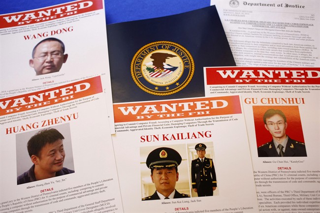 FILE - This May 19, 2014 file photo shows press material displayed at the Justice Department in Washington before a press conference by U.S. Attorney General Eric Holder to announce charges of economic espionage and trade secret theft against five Chinese military officers, all hackers in an international cyber-espionage case. 
