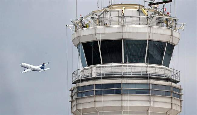 In this March 24, 2011 file photo, a passenger jet flies past the FAA control tower at Washington's Ronald Reagan National Airport.