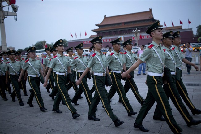 Paramilitary policemen march on Tiananmen Square after a flag-lowering ceremony on Tiananmen Square in Beijing, China, Wednesday, June 4, 2014.